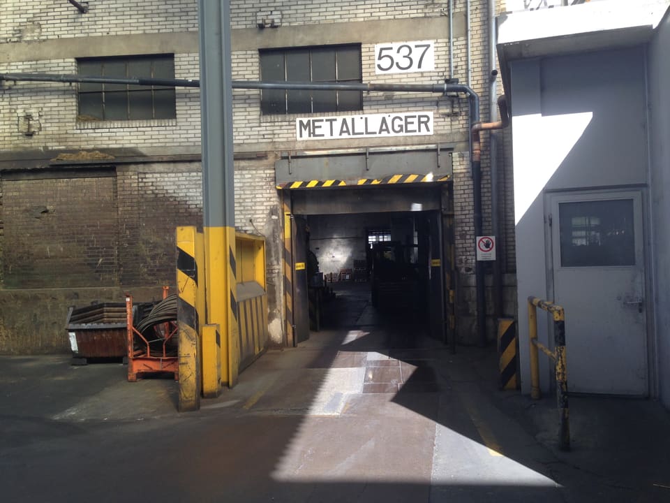 Der Eingang in eine alte Industriehalle - ein Eingang steht das Wort Metallager