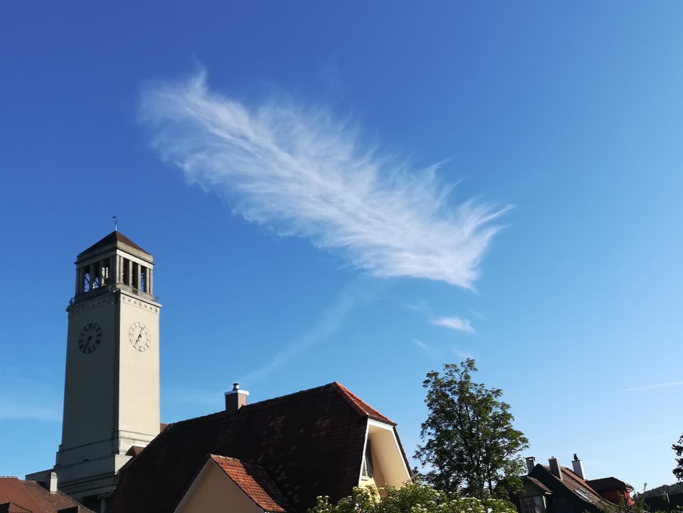 Ein wolke, wie eine Feder, schwebt über der Kirche.