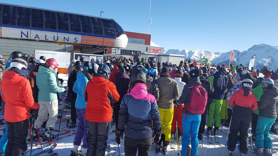 Skifahrer stehen an beim Skilift Naluns in Scuol