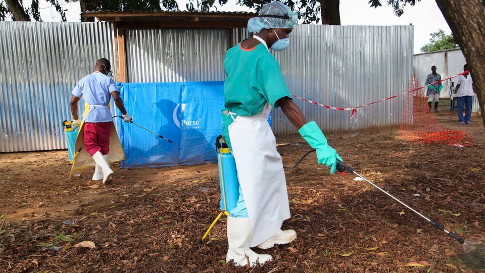 Pfleger versprühen Desinfektionsmittel in Monrovia (Liberia).