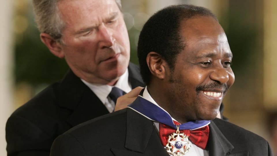 Bush steht hinter Rusesabagina und legt ihm eine Medaille um