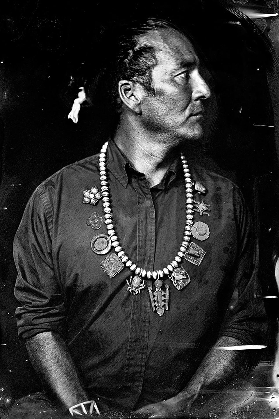 Der Fotograf Will Wilson mit Indianerkette und traditioneller Indianerfrisur. Ein historisch anmutendens Portraitfoto.