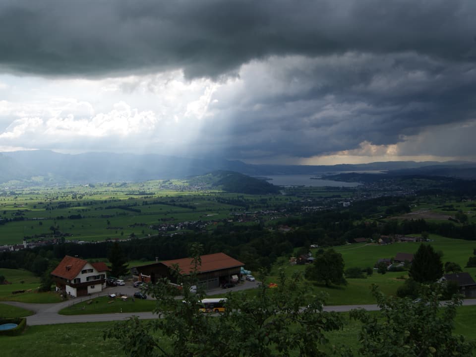 Dunkle Wolken und Regen, im Hintergrund der Zürichsee.