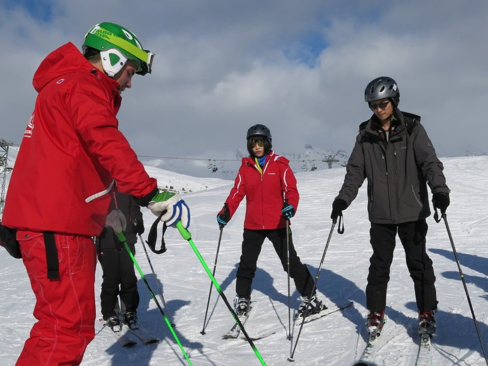 Jugendliche lernen Skifahren.