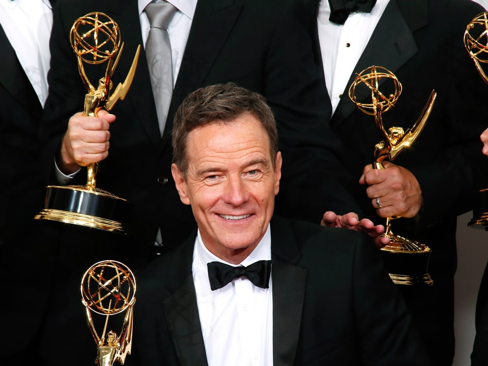 Schauspieler im schwarzen Anzug mit Emmy-Auszeichnung in der Hand.