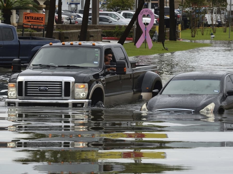 Autos stecken in Texas in den Fluten fest.