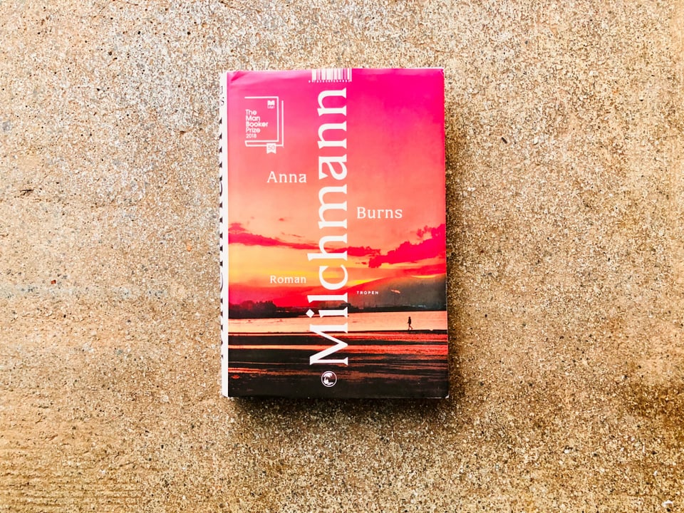 Der Roman «Milchmann» von Anna Burns liegt auf einem grauen Zementboden