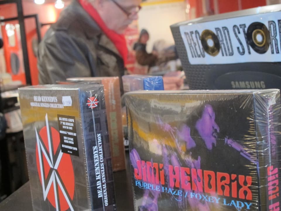 CD-Box von Jimi Hendrix im Vordergrund, älterer Kunde im Hintergrund
