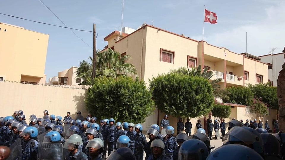 Polizisten in Kampfmontur stehen vor der Schweizer Botschaft in Tripolis.