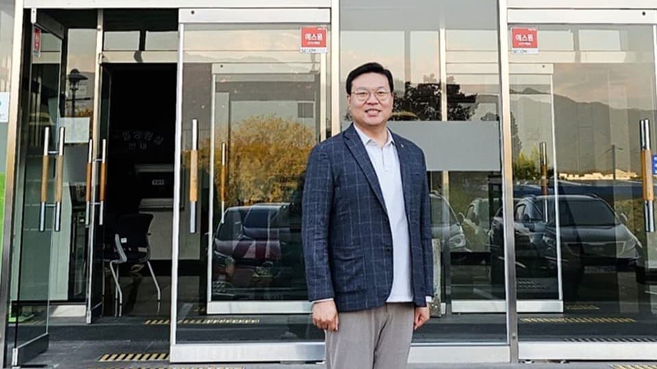 Militärwissenschaftler Choi Gi-il steht vor einem Gebäude mit einer grossen Glastür.