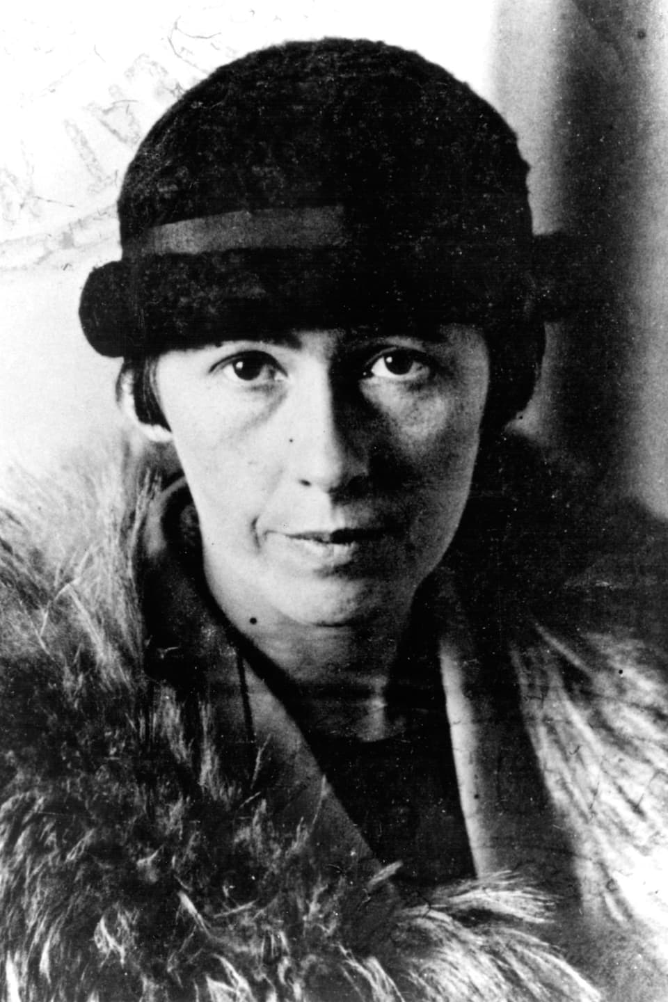 Foto (schwarz weiss) von einer Frau mit Hut und Pelzstola. 