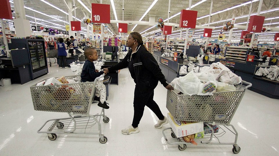 Ein Frau mit zwei gefüllten Einkaufswagen in einem grossen Shoppingcenter in den USA.