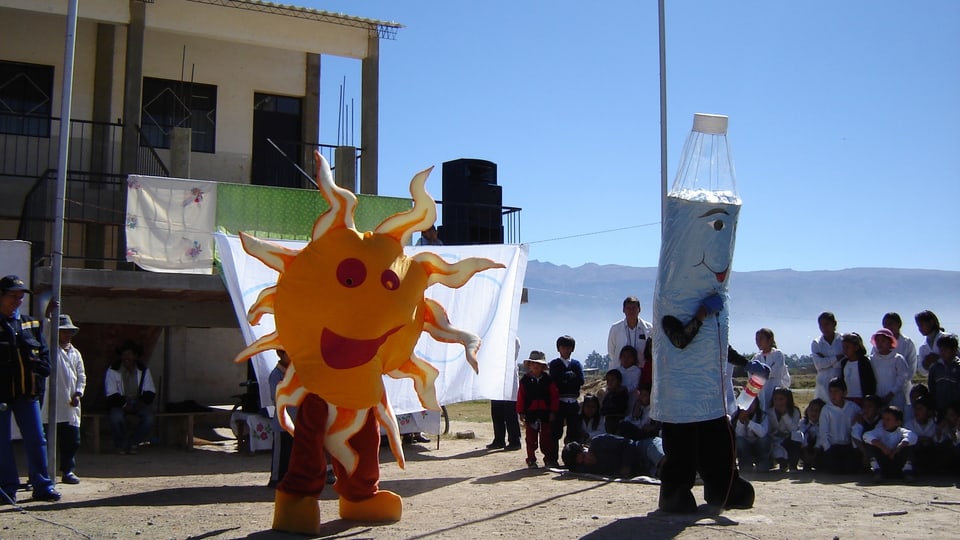 Schauspiel in Kostümen als Sonne und Pet-Flasche erklären die Sodis-Methode der Bevöllkerung in Bolivien..