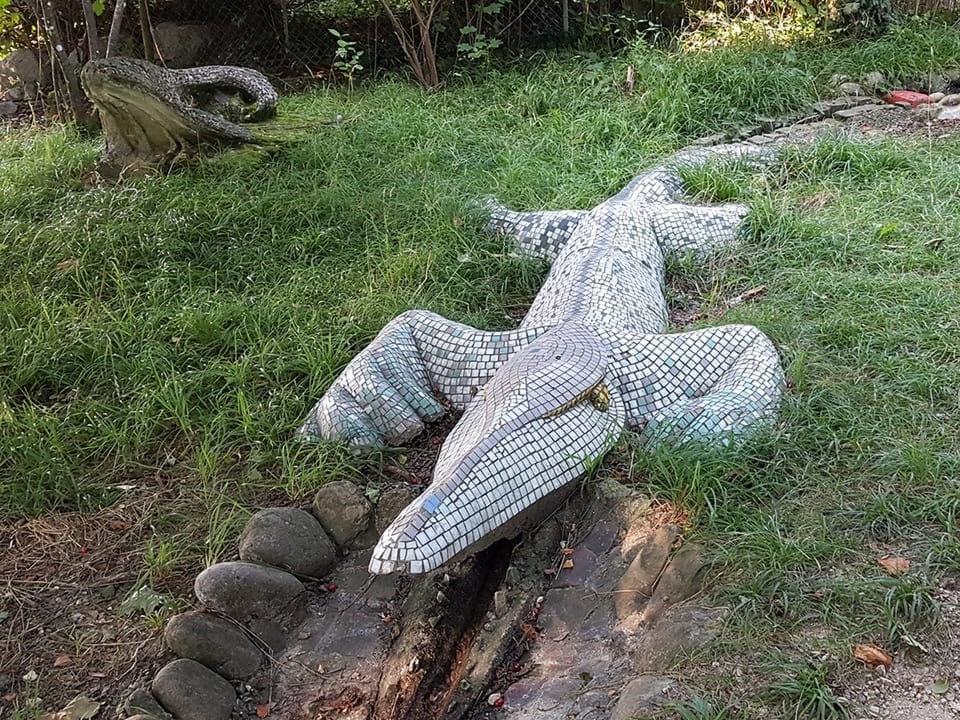 Ein mit Mosaiksteinen besetztes Krokodil aus Stein.