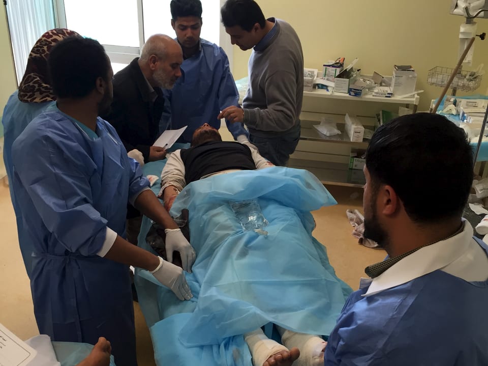Verletzter auf einer Bahre wird von Ärzten in einem Spital versorgt.