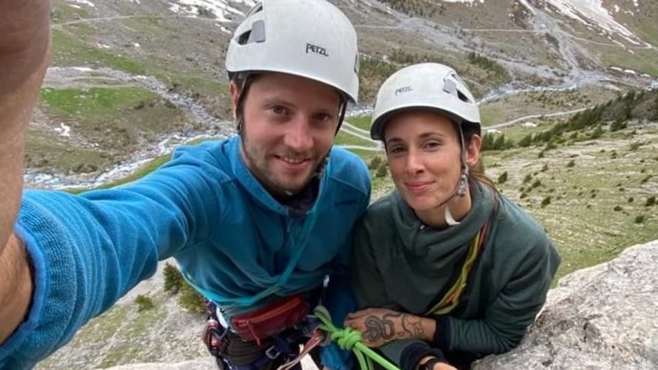 Selfie: Paar mit Helmen, angeseilt an einem Berg