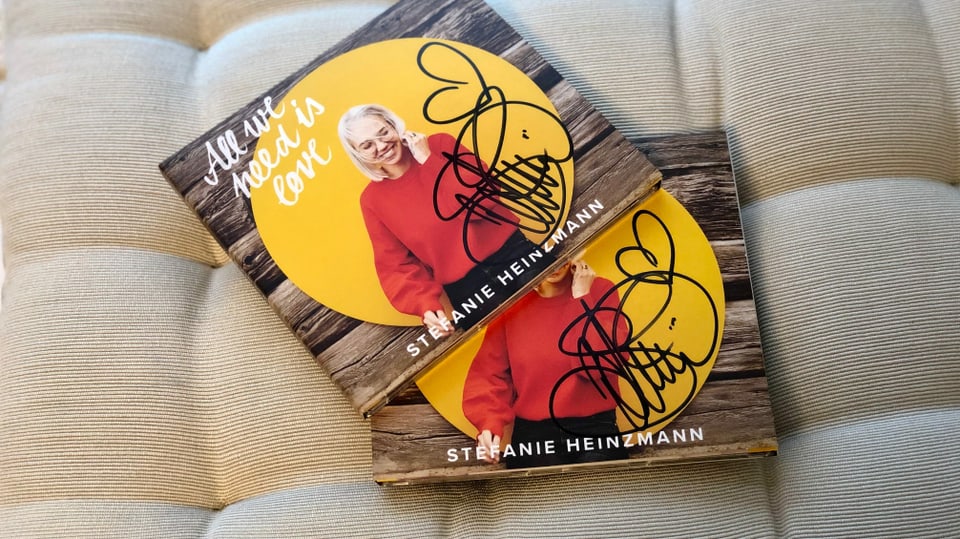 2 CDs von Stefanie Heinzmann liegen auf einem Kissen.