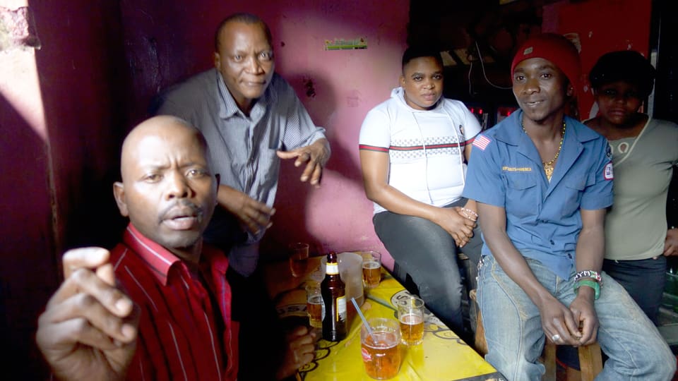 Schwarze Männer beim Biertrinken in einer Bar.
