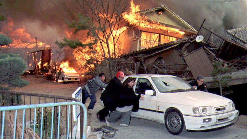 Menschen vor einem brennenden Haus