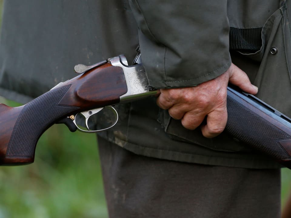 Ein Jäger hält ein Gewehr in der Hand.