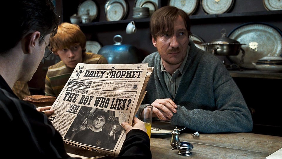 Remus Lupin in «Harry Potter». Er sitzt an einem Tisch.