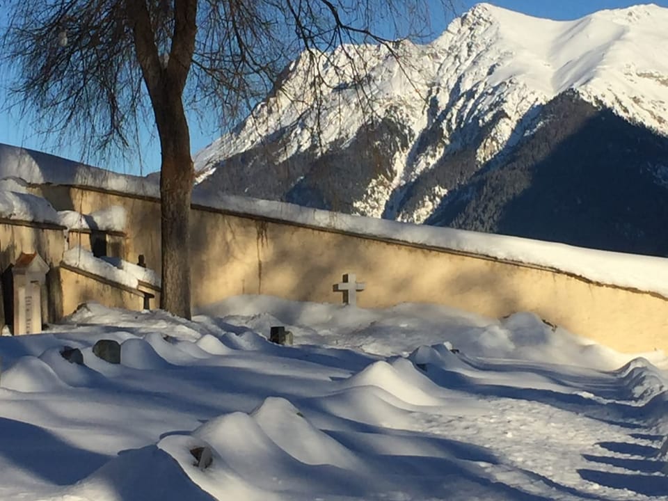 Schneebedeckter Friedhof in den Bergen