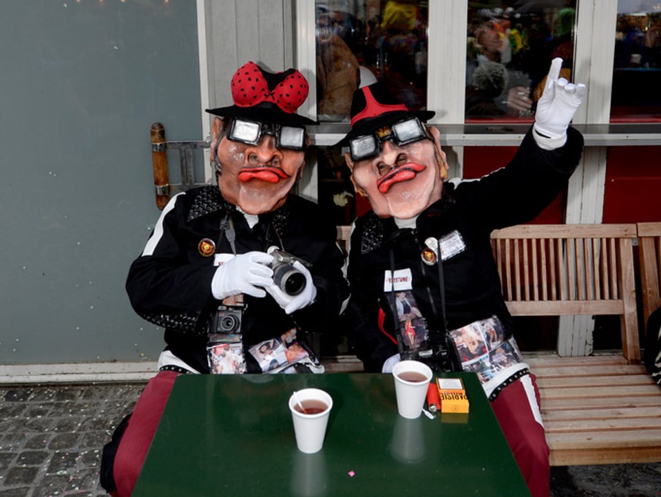 Zwei Einzelmasken bei einem Kaffee Schnaps an der Luzerner Fasnacht. 