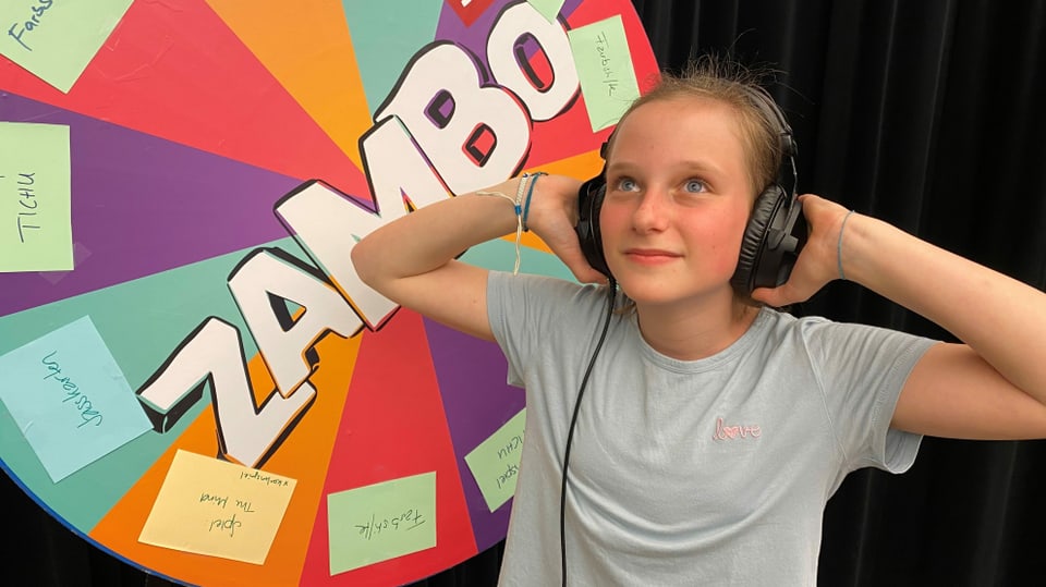 Ein Mädchen mit Kopfhörer vor dem Zambo-Logo