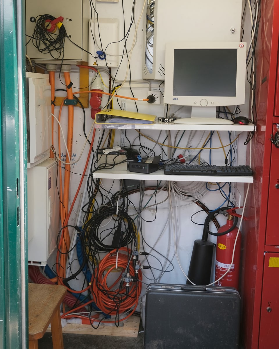 Computerbildschirm in einer Baracke und viele Kabel.