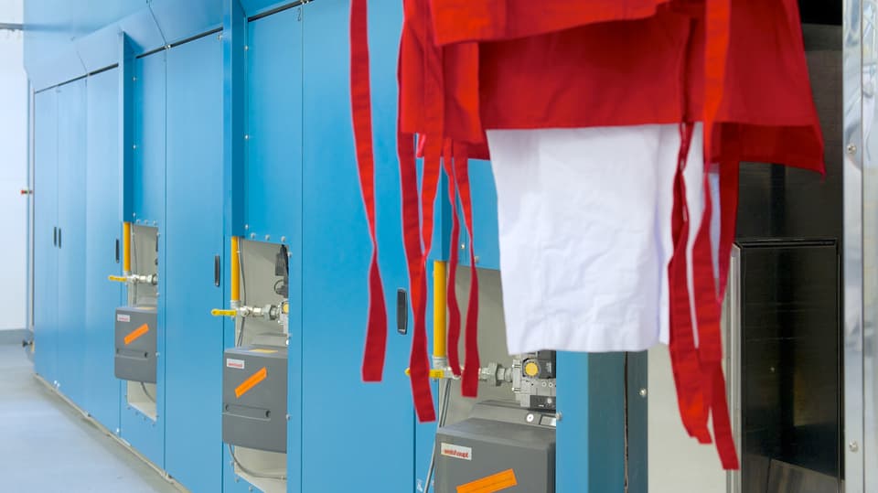 Die noch nasse saubere Wäsche wird im Trocknungstunnel automatisch getrocknet.