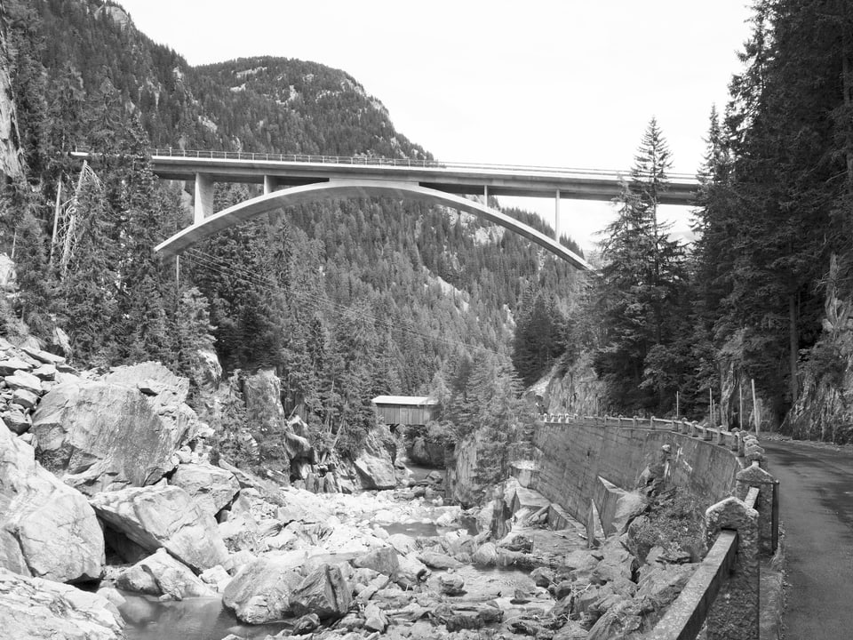 Schwarz-Weiss-Aufnahme einer Brücke über einem Bergbach