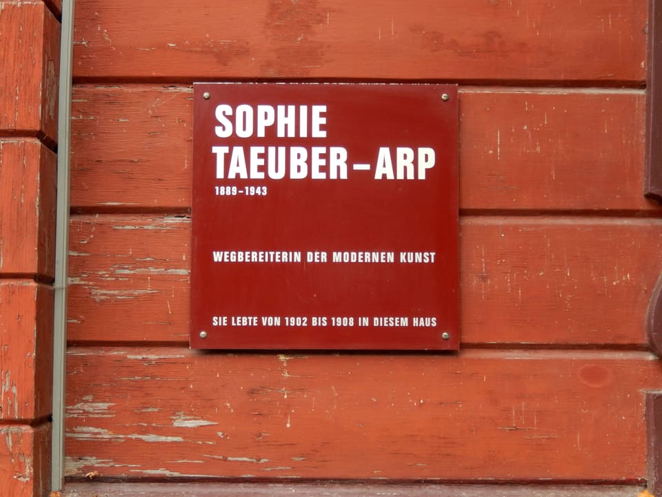 Eine rote Tafel erinnert an Sophie Taeuber-Arp.