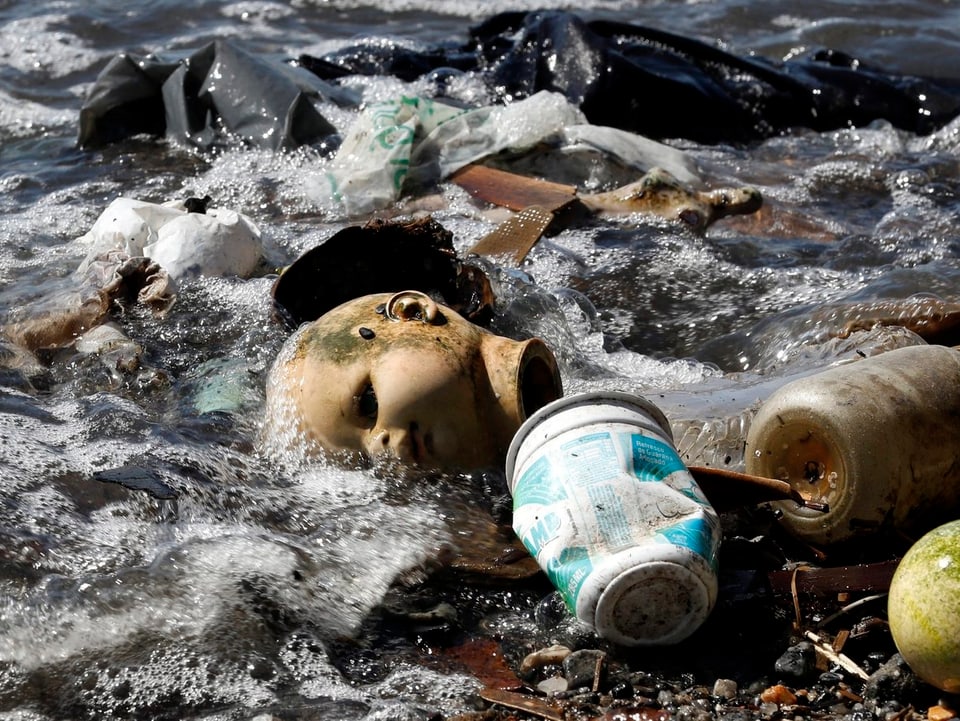 Büchsen, Plastiksäcke, Flaschen und eine Kinderpuppe werden ans Ufer angschwemmt