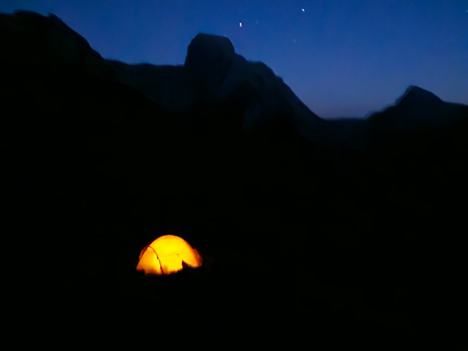 Beleuchtetes Zelt in der Nacht bei klarem Himmel.