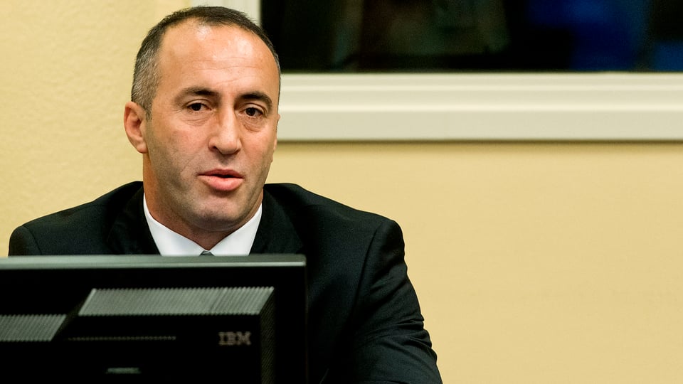 Haradinaj sitzt vor einem Bildschirm, Aufnahme aus der Gerichtsverhandlung in Den Haag.