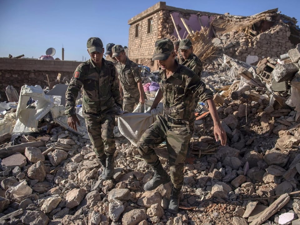 Einsatzkräfte der Armee bergen ein Todesopfer aus den Trümmern.