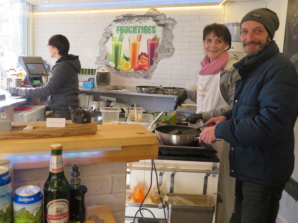 Leute bereiten Essen vor, das bei der Rondelle gekauft werden kann. 