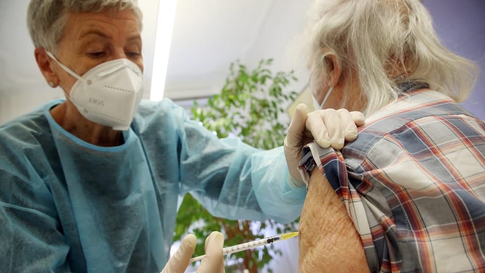 Ein älterer Mann lässt sich die dritte Impfung mit dem Impfstoff von Pfizer/Biontech injizieren.