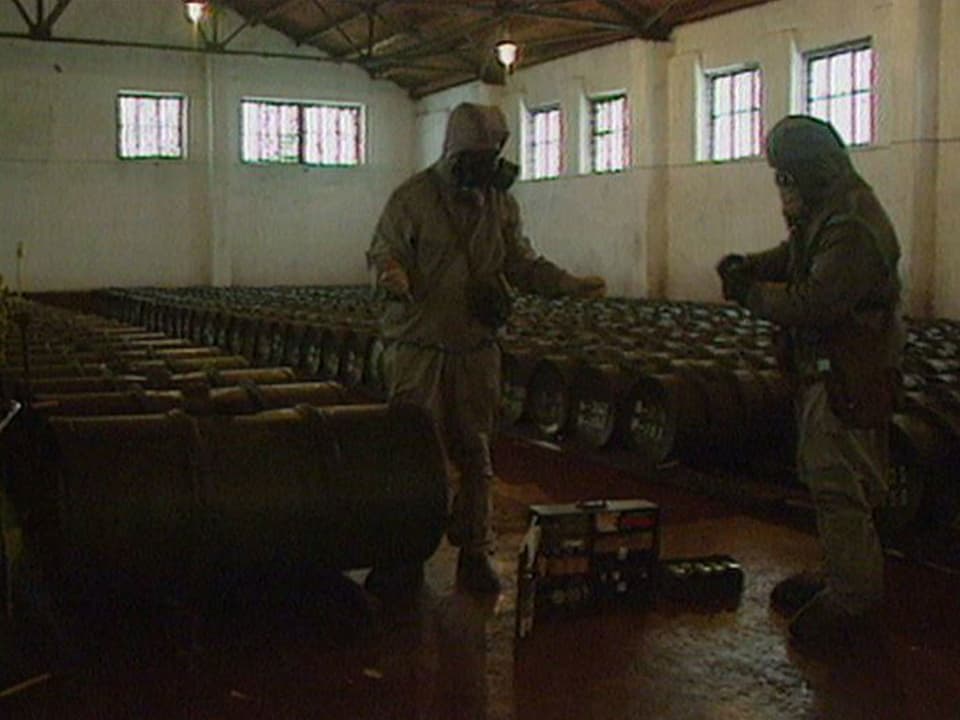 Soldaten in einer Halle mit Behältern.