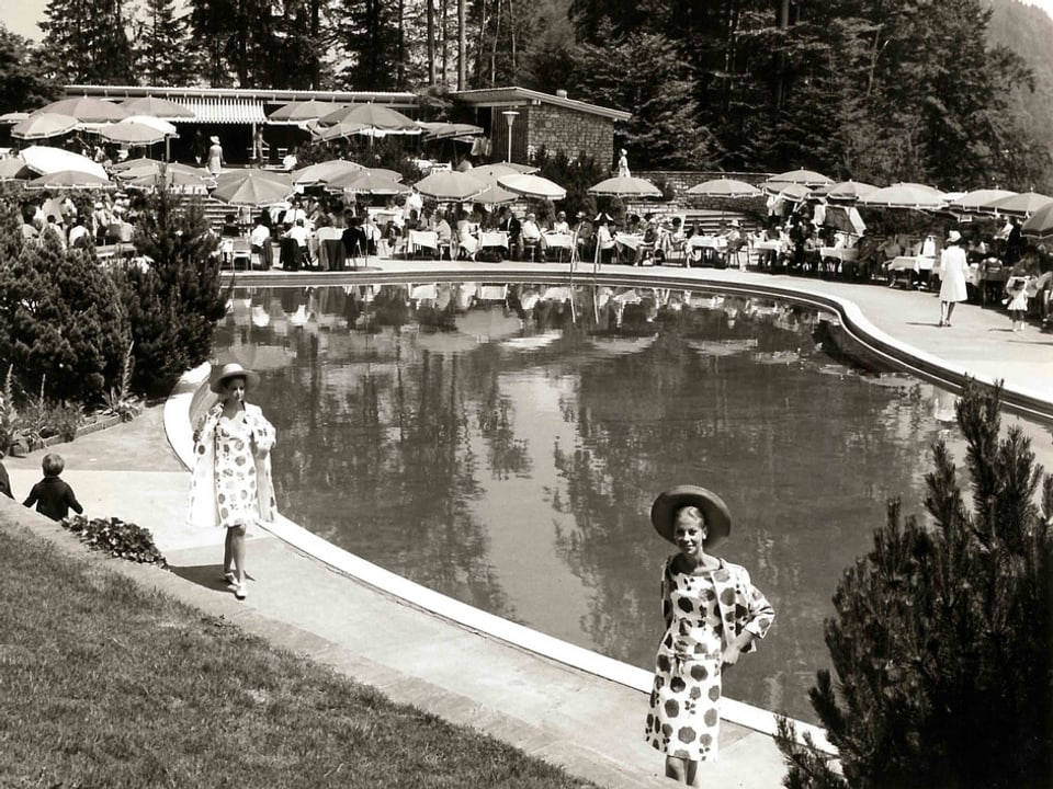 Frauen stehen vor einem Swimmingpool.