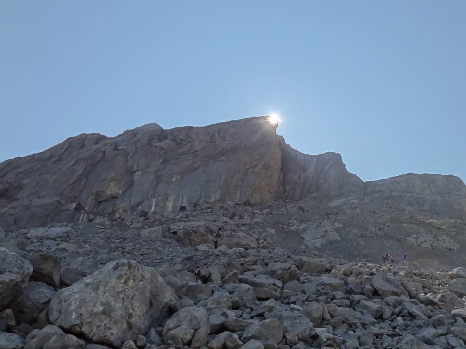 Die Sonne ist knapp hinter einer Felsecke zu erkennen.