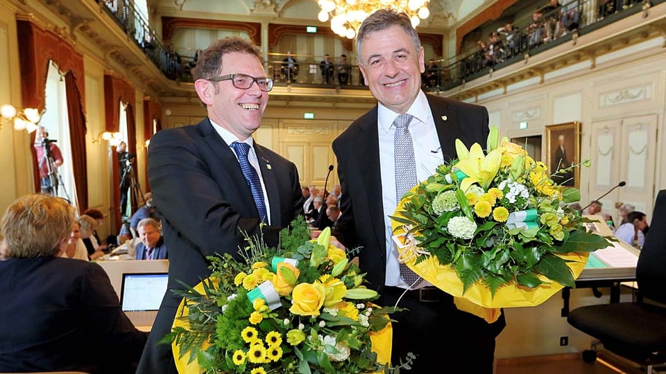 Zwei lachende Männer mit Blumenstrauss