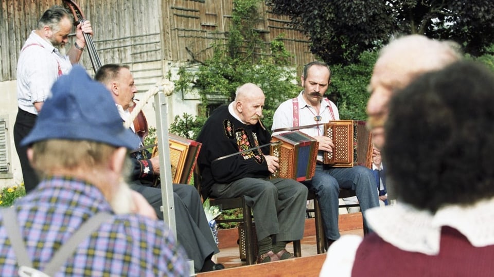 Vier Musikanten mit Handörgeli und Bass.