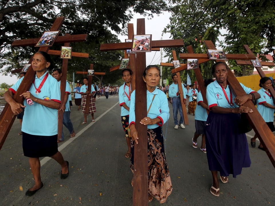 Frauen prozessieren mit Holzkreuzen