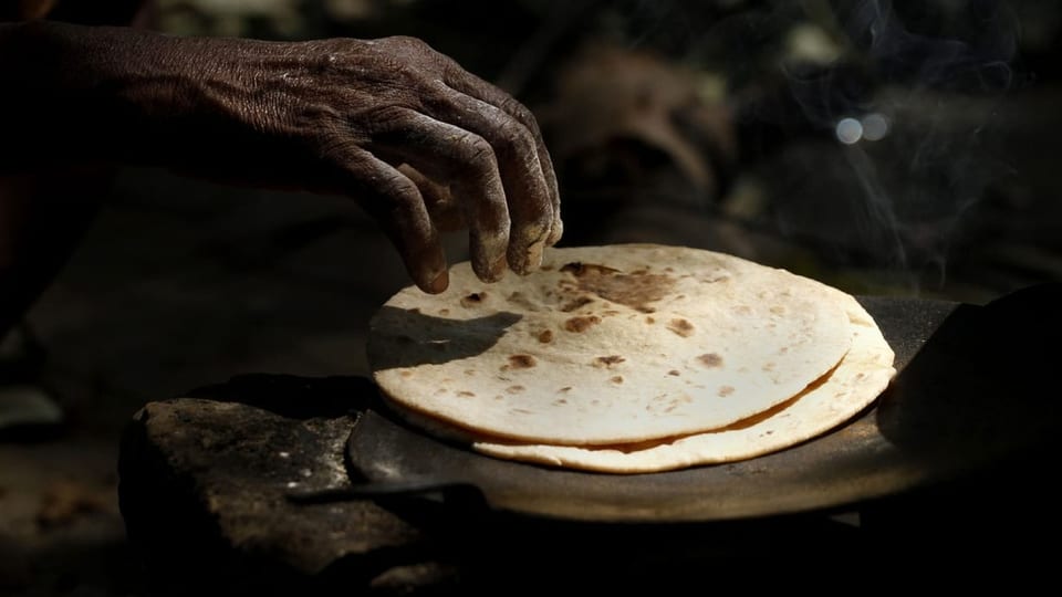 Stapel Chapatis, eine Hand, die danach greift