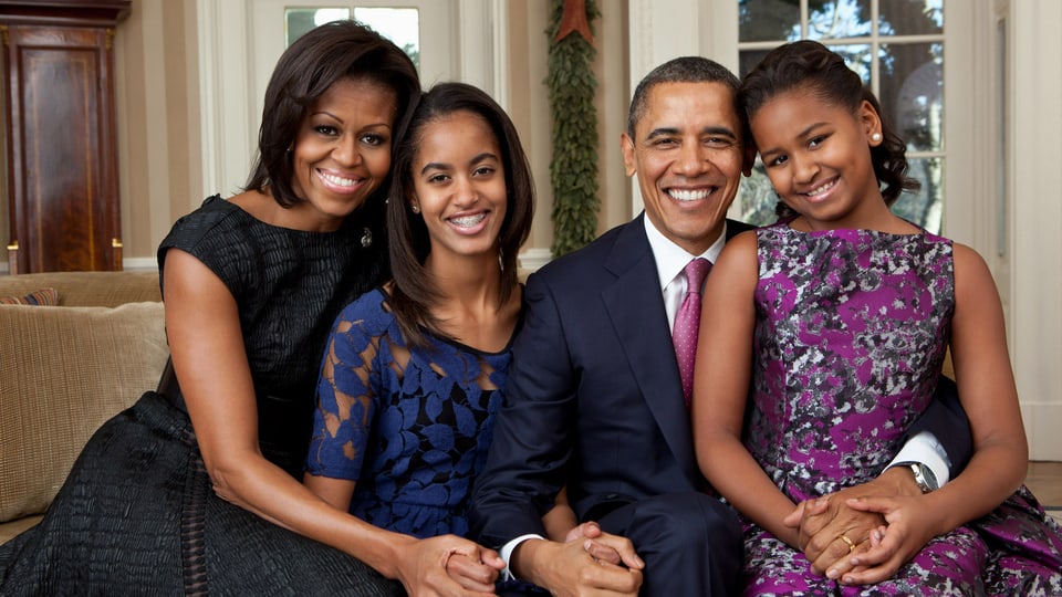 Familien Foto: Michelle Obama, Malia Ann Obama, Barack Obama und Natasha Obama auf einem Sofa sitzend und lächelnd.