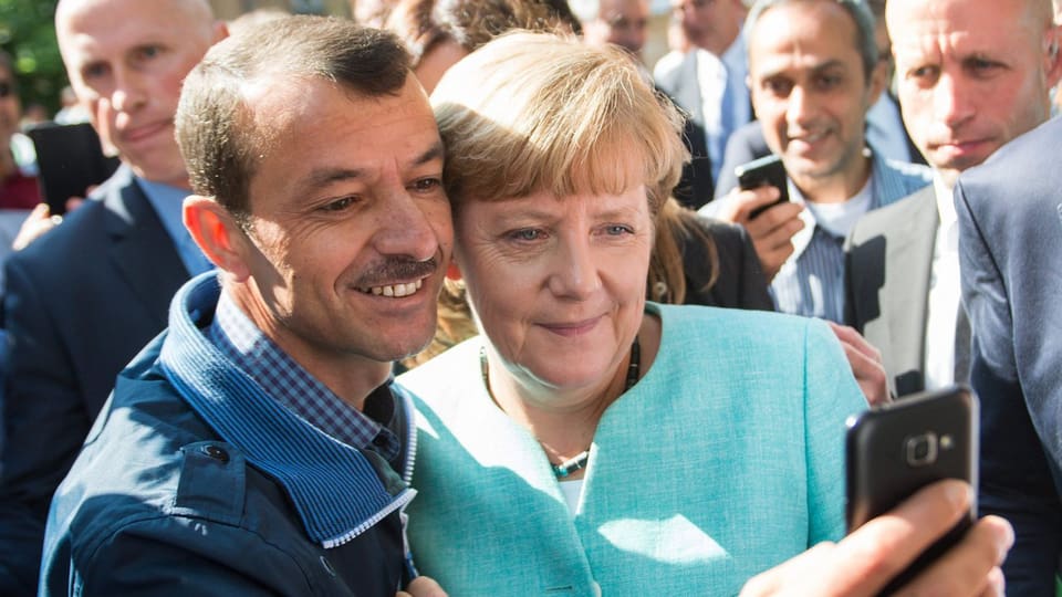 Flüchtling schiesst ein Foto von sich und Angela Merkel