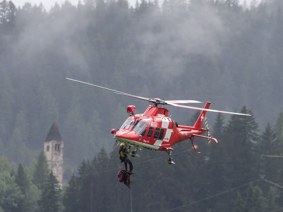 Regahelikopter mit einem Helfer in der Luft.