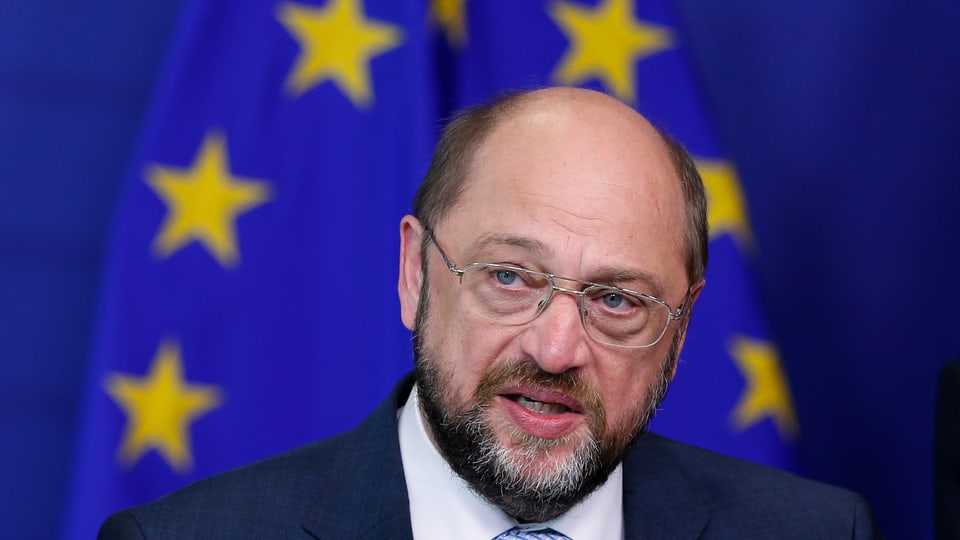 Martin Schulz, mit Brille und Bart, spricht vor der Europa-Flagge