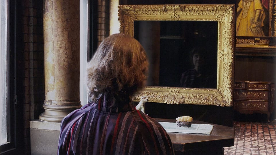 Eine Frau betrachtet ihre Reflexion in einem leeren Bilderrahmen.